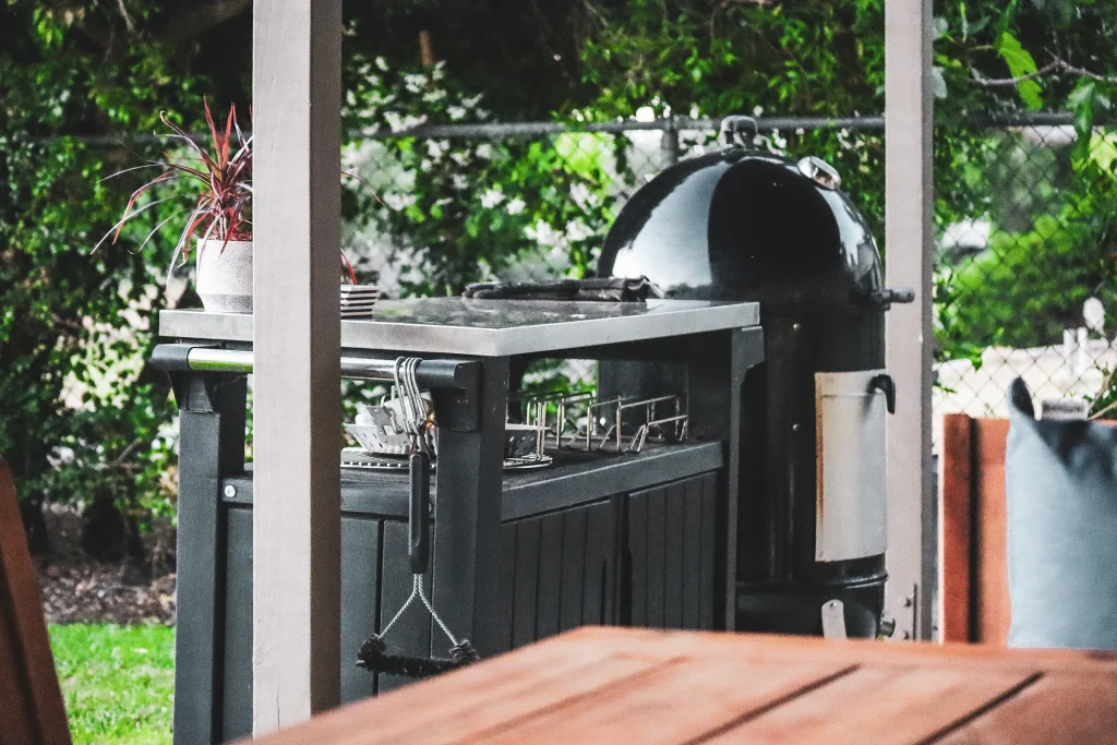 Backyard barbecue grill surrounded by plants