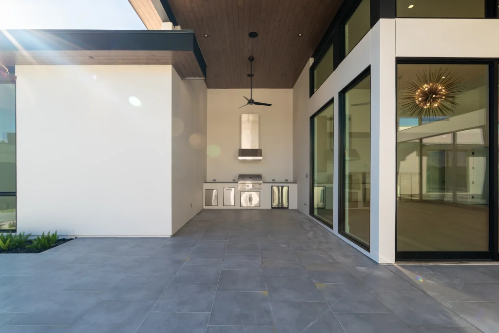 Sleek covered patio with a built-in outdoor kitchen and bar seating