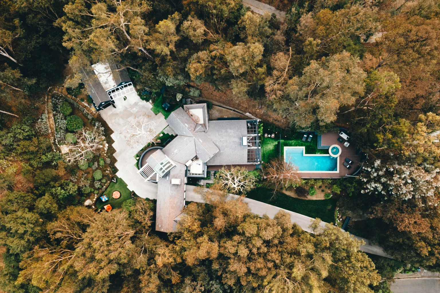 Aerial view of a California home and backyard surrounded by trees