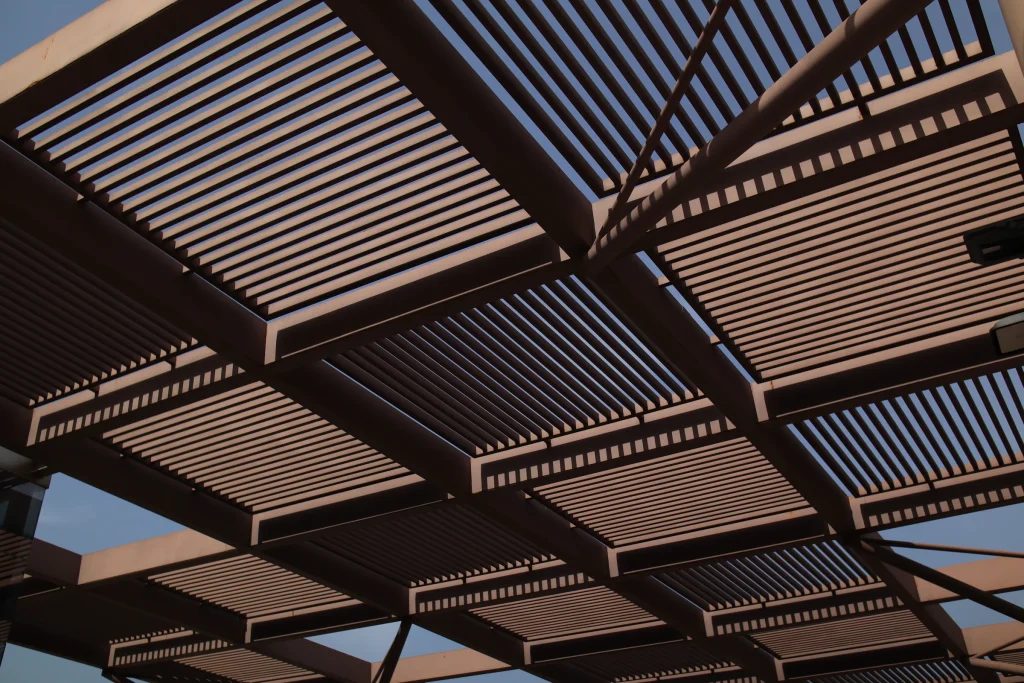Close-up of a metal shade structure against a blue sky