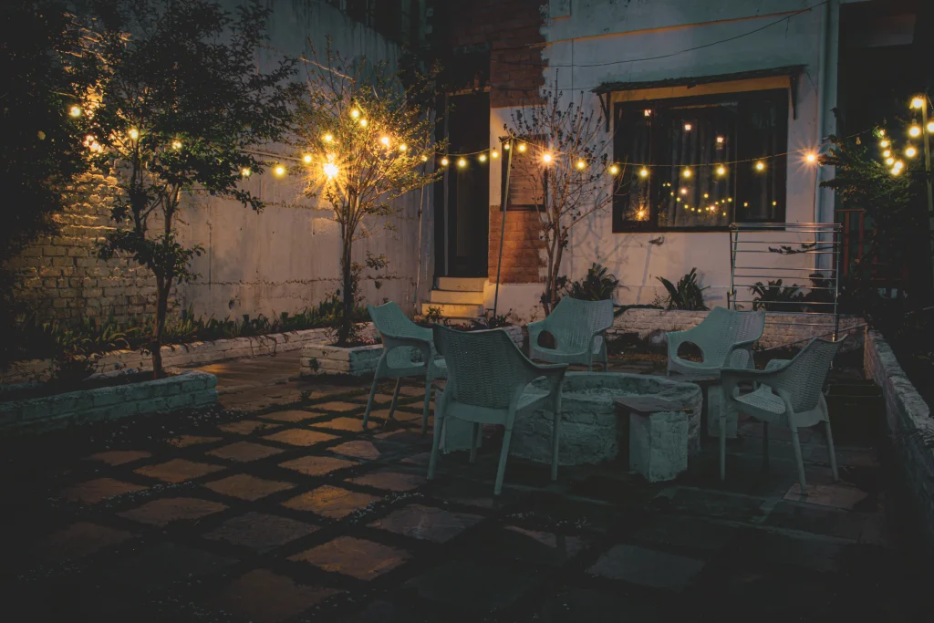 Patio table and chairs softly lit by outdoor lights at night