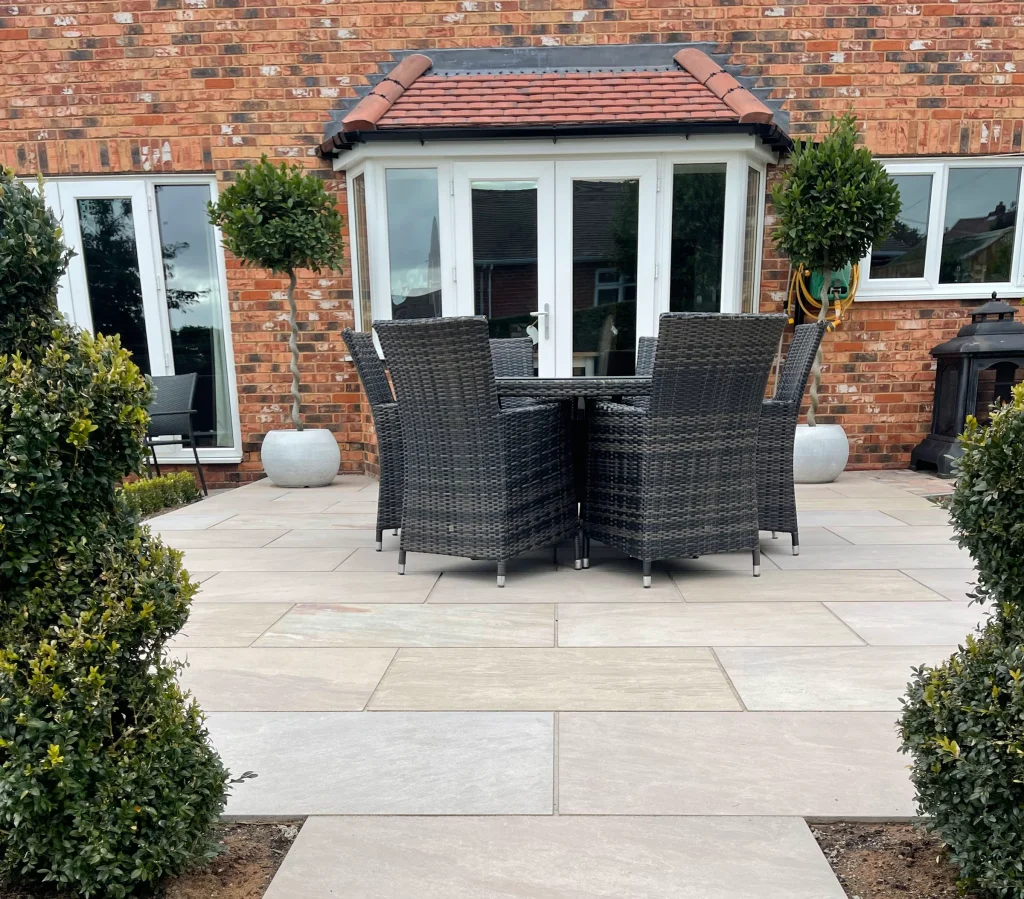 Landscaped paver patio with garden furniture and plantings