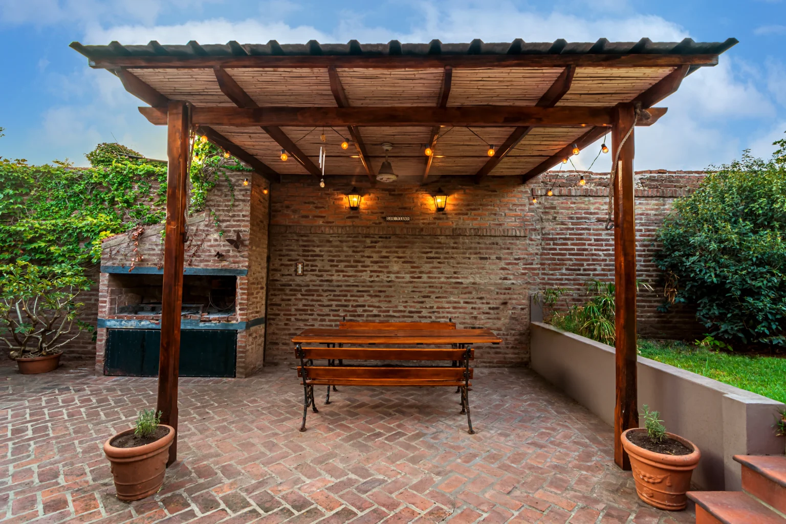 Warm wood pergola casting slatted shade over a garden bench